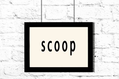 Beyaz tuğla duvarda asılı siyah çerçeve ve yazı kepçesi