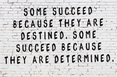 Beyaz tuğla duvar arkaplanına siyah düşünceli bir yazı.