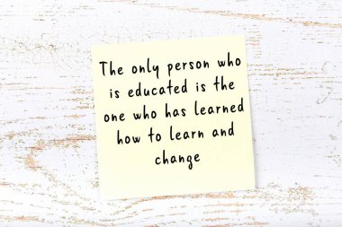 Ahşap duvardaki sarı yapışkan notta bilgece bir alıntı var.