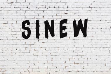 Kelimeler beyaz tuğla duvarda boyanmış.