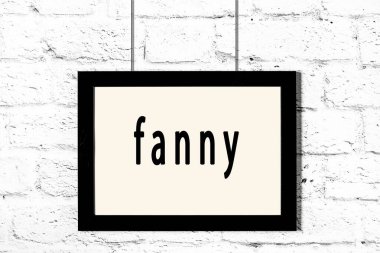 Beyaz tuğla duvarda asılı siyah çerçeve.