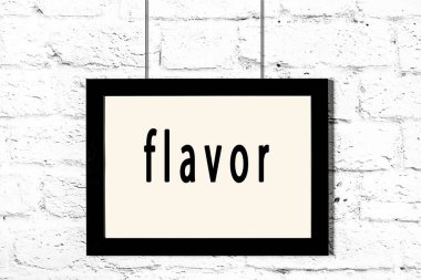 Beyaz tuğla duvarda asılı siyah çerçeve.