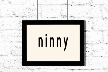 Beyaz tuğla duvarda asılı siyah çerçeve.