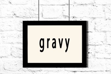 Beyaz tuğla duvarda asılı siyah çerçeve.