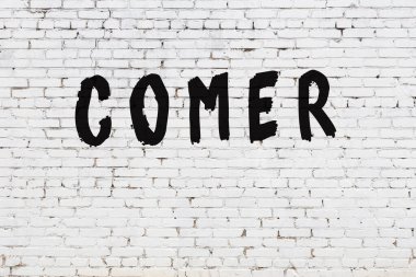 Beyaz tuğla duvara yazı yazan kişi.