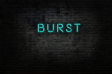 Üzerinde yazı olan neon levhası tuğla duvara çarpıyor.