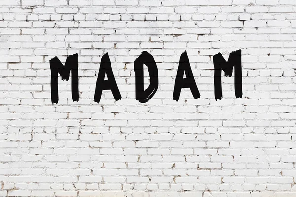 Słowo madam malowane na białej cegły ściany — Zdjęcie stockowe