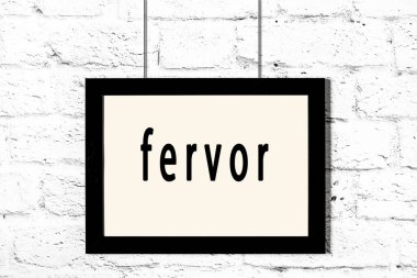 Beyaz tuğla duvarda asılı siyah çerçeve.