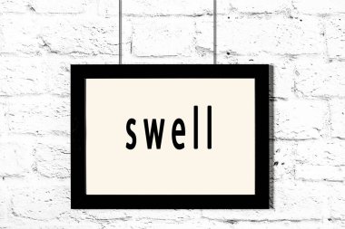 Beyaz tuğla duvarda asılı duran siyah çerçeve.