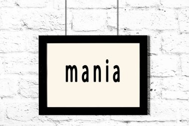 Beyaz tuğla duvarda asılı siyah çerçeve ve yazı çılgınlığı