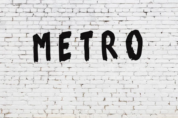 Слово метро окрашено на стене из белого кирпича — стоковое фото