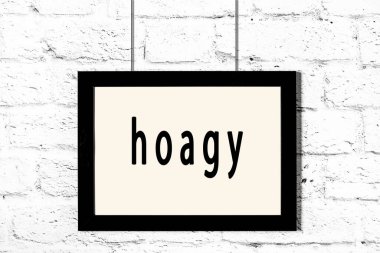 Beyaz tuğla duvarda asılı siyah çerçeve.