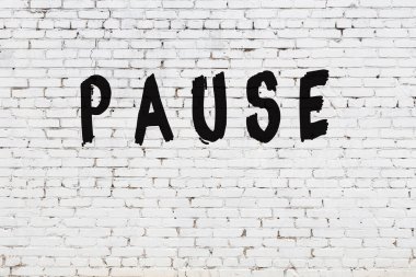 Üzerinde siyah boya yazan beyaz duvar duraklat.