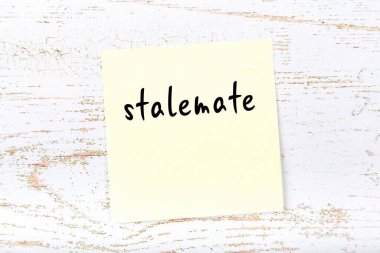 Tahta duvarda el yazısıyla yazılmış bir çıkmazla sarı yapışkan not.