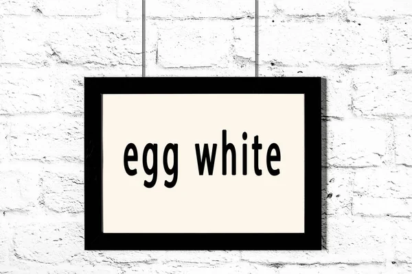 Marco negro colgando en la pared de ladrillo blanco con la inscripción clara de huevo —  Fotos de Stock