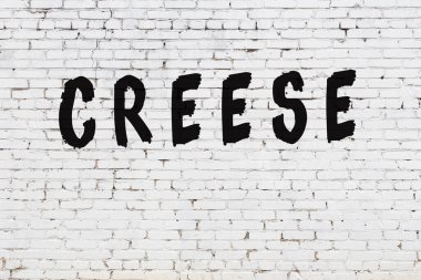 Üzerinde siyah boya ve krep olan beyaz bir duvar.