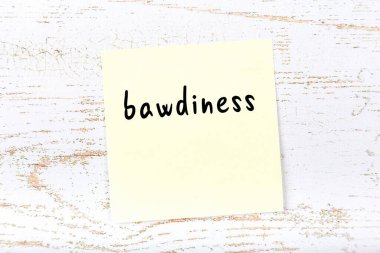 Tahta duvardaki sarı yapışkan notta el yazısı müstehcenlik var.