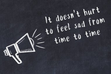 Tebeşir hoparlörü ve siyah masada akıllıca bir alıntı.