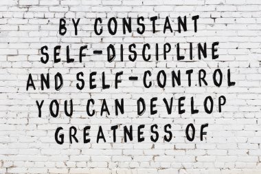 Beyaz tuğla duvar arkaplanına siyah düşünceli bir yazı.