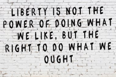 Bilgece alıntıların yazılı olduğu siyah boyanmış beyaz tuğla duvar