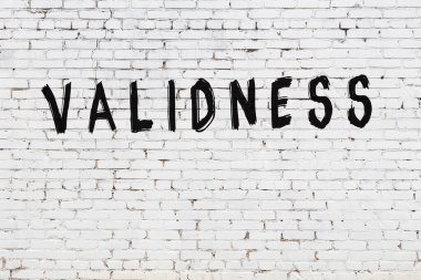 Üzerinde siyah boya yazıları olan beyaz duvar.