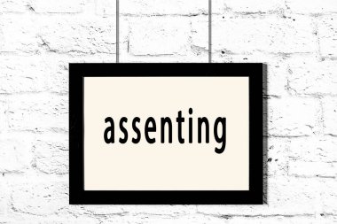 Beyaz tuğla duvarda asılı duran siyah çerçeve.