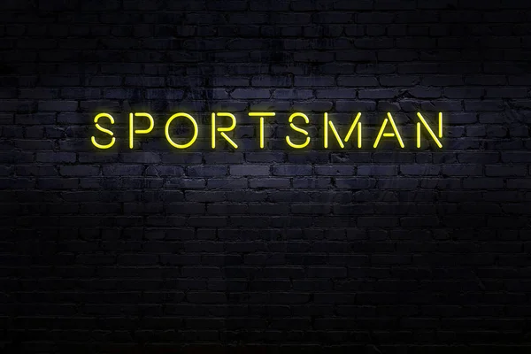 Nattutsikt över neon skylt på tegelvägg med inskription idrottsman — Stockfoto