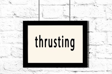 Beyaz tuğla duvarda asılı duran siyah çerçeve.