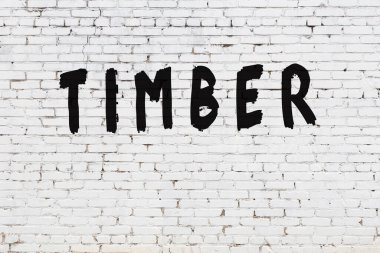 Üzerinde siyah boya yazılı kereste olan beyaz duvar.