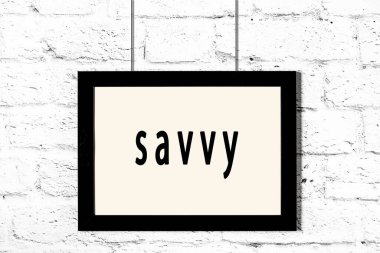 Beyaz tuğla duvarda asılı siyah çerçeve.