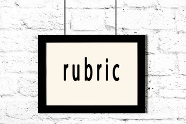 Beyaz tuğla duvarda asılı siyah çerçeve.