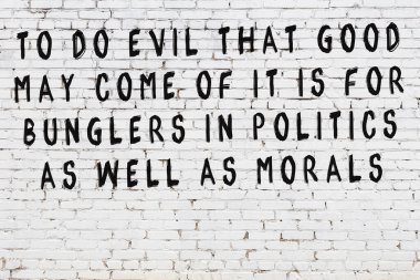 Beyaz tuğla duvar arkaplanına siyah düşünceli bir yazı.