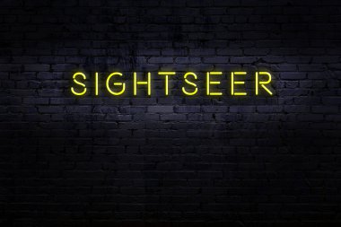 Tuğla duvardaki neon ışıklı tabelanın gece görüşü.