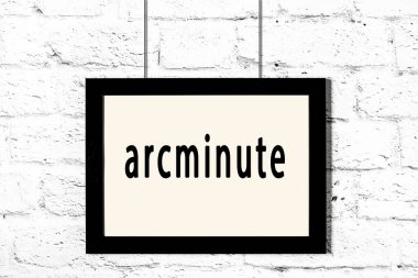 Beyaz tuğla duvarda asılı duran siyah çerçeve.