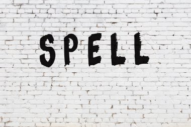 Beyaz tuğla duvara yazılmış kelime büyüsü.