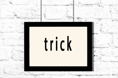 Beyaz tuğla duvarda asılı siyah çerçeve.