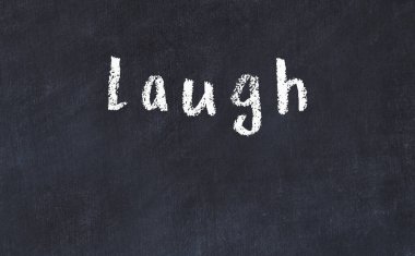 Üzerinde kahkaha yazan tebeşir masası.