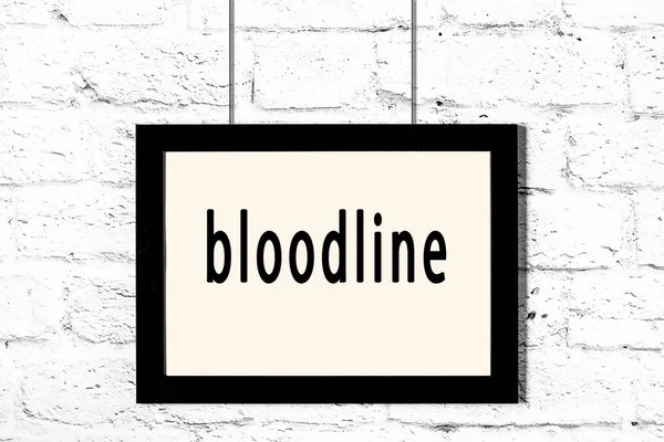 Quadro preto pendurado na parede de tijolo branco com inscrição bloodline — Fotografia de Stock