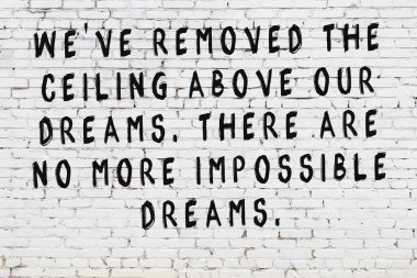 Beyaz tuğla duvar arkaplanına siyah düşünceli bir yazı.