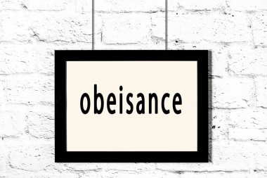 Beyaz tuğla duvarda asılı duran siyah çerçeve.