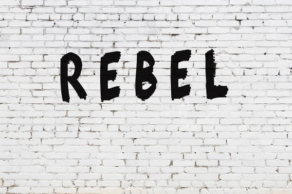 Mot rebelle peint sur un mur de briques blanches — Photo