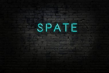 Üzerinde yazı olan neon levhası tuğla duvara çarpıyor.