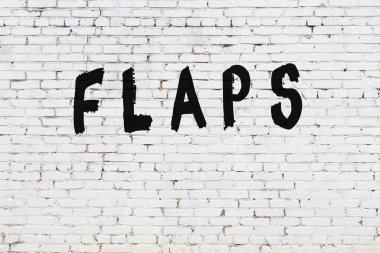 Kelime kanatları beyaz tuğla duvara boyanmış.