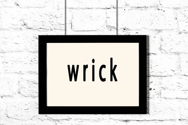 Quadro preto pendurado na parede de tijolo branco com inscrição wrick — Fotografia de Stock