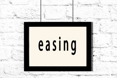 Beyaz tuğla duvarda asılı siyah çerçeve ve yazıt kolaylaştırıcı