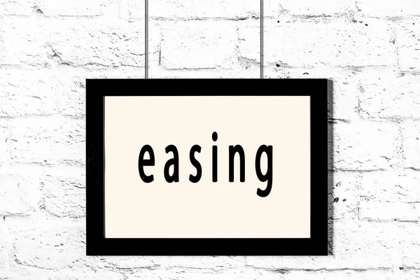 Beyaz tuğla duvarda asılı siyah çerçeve ve yazıt kolaylaştırıcı