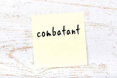 Tahta duvardaki sarı yapışkan notta el yazısıyla yazılmış savaşçı yazıyor.