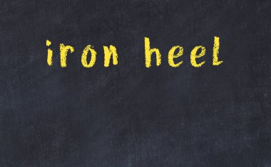 Üzerinde demir topuk yazan siyah karatahta.