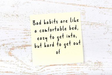 Ahşap duvardaki sarı yapışkan notta bilgece bir alıntı var.