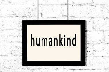 Beyaz tuğla duvarda asılı siyah çerçeve.